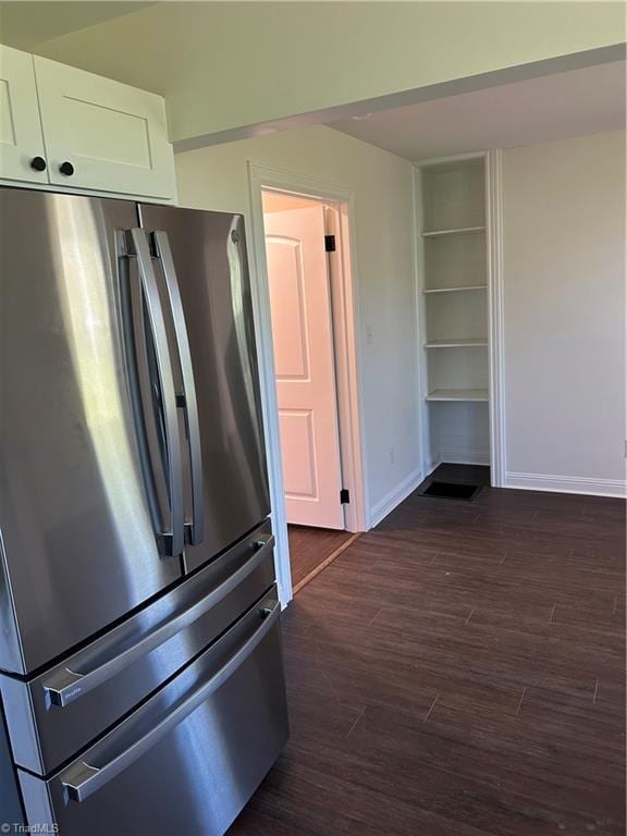 kitchen with baseboards, dark wood-style flooring, white cabinetry, and freestanding refrigerator