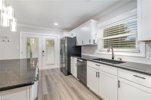 kitchen featuring light hardwood / wood-style floors, sink, white cabinetry, appliances with stainless steel finishes, and decorative light fixtures