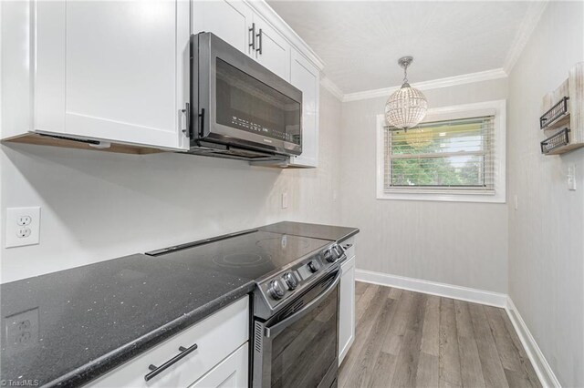 kitchen featuring white cabinetry, sink, stainless steel appliances, and decorative light fixtures