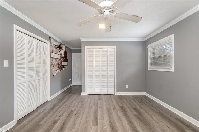 unfurnished bedroom with light wood-type flooring, a closet, a textured ceiling, and crown molding