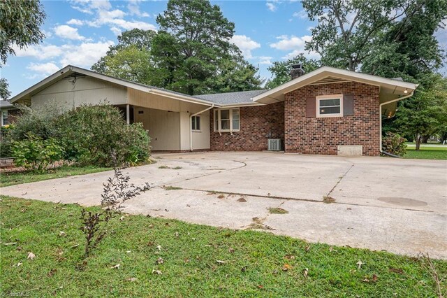 single story home featuring a front yard, central AC, and a carport