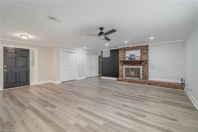 unfurnished living room featuring ceiling fan, a fireplace, and light hardwood / wood-style floors