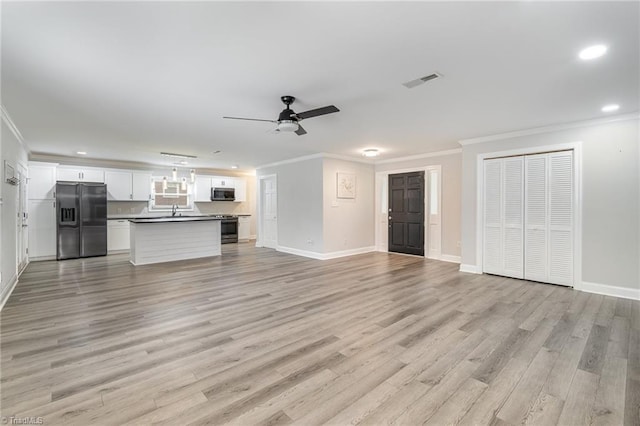 unfurnished living room with ceiling fan, ornamental molding, sink, and light hardwood / wood-style floors