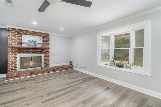 unfurnished living room with a brick fireplace, light hardwood / wood-style floors, ceiling fan, and crown molding