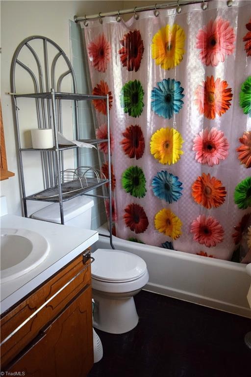 full bathroom with vanity, shower / bath combo, and toilet