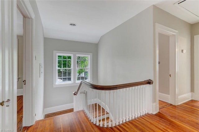 stairway featuring vaulted ceiling and hardwood / wood-style floors