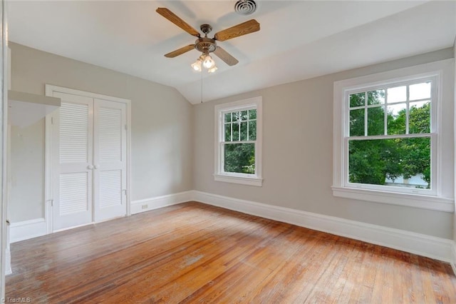 empty room with ceiling fan, lofted ceiling, light hardwood / wood-style floors, and a wealth of natural light