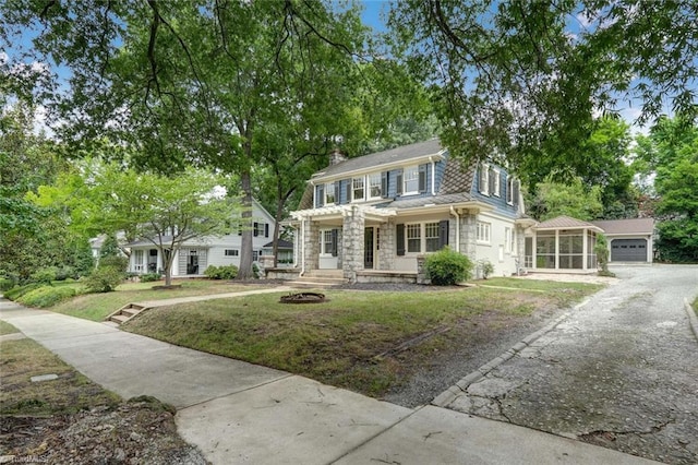 view of front of home featuring a front lawn, a porch, and a garage