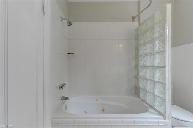 bathroom with tiled shower / bath combo and toilet