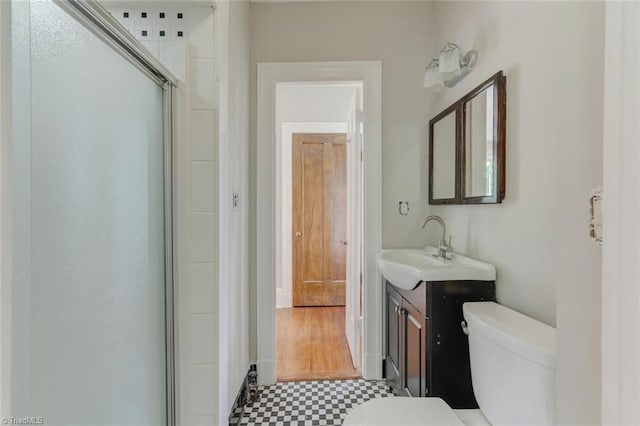 bathroom with vanity, toilet, and a shower with shower door