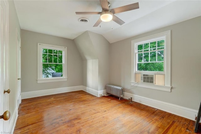 bonus room with radiator, light hardwood / wood-style floors, plenty of natural light, and vaulted ceiling