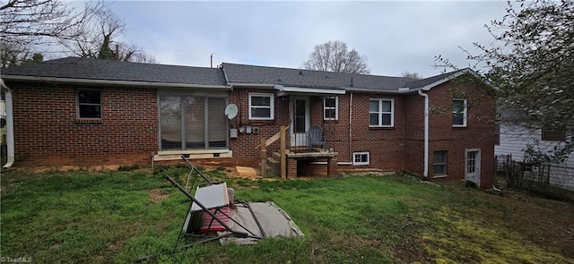 rear view of house featuring a yard and brick siding