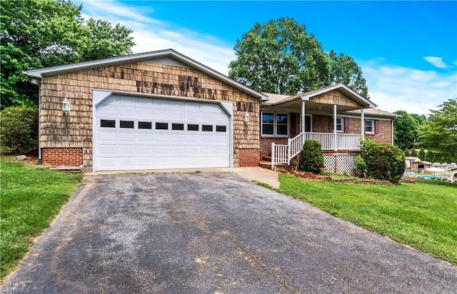 103 E St, Jonesville, NC 28642 - ranch-style home with driveway, covered porch, a front lawn, brick siding, and a garage