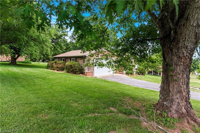 103 E St, Jonesville, NC 28642 - view of front of house featuring a front yard, an attached garage, and driveway