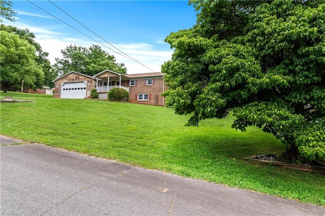 103 E St, Jonesville, NC 28642 - view of front of house with brick siding, a front yard, and an attached garage