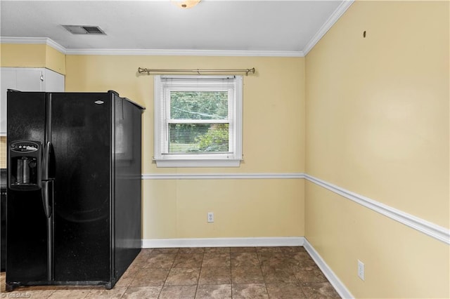 103 E St, Jonesville, NC 28642 - kitchen with black fridge, ornamental molding, and white cabinetry