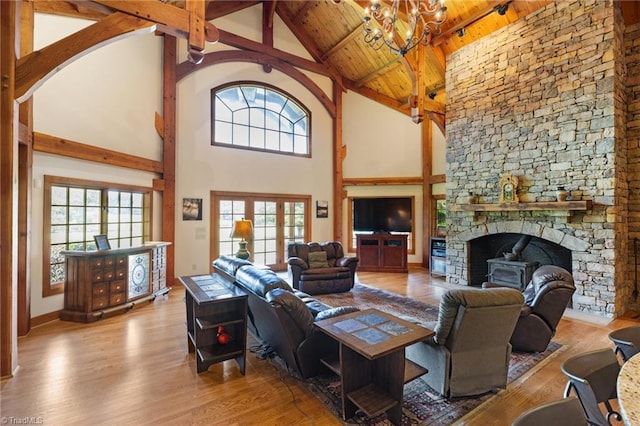 7239 Bulb Rd, Julian, NC 27283 - living room with wood finished floors, high vaulted ceiling, a chandelier, a wooden ceiling with exposed beams, and a stone fireplace