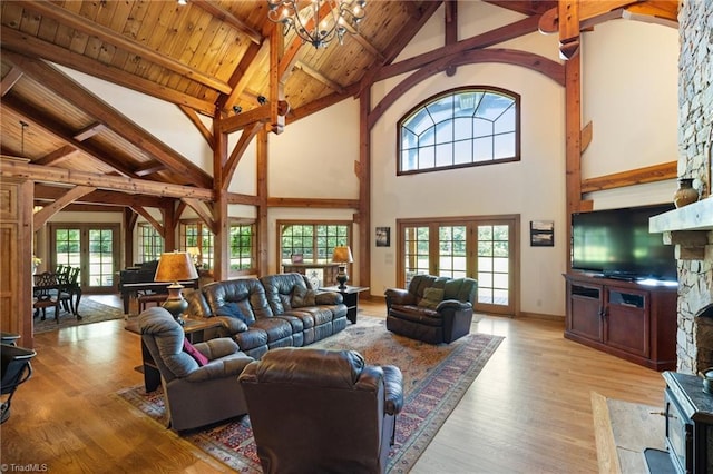 7239 Bulb Rd, Julian, NC 27283 - living area featuring high vaulted ceiling, light wood-style floors, a chandelier, a wood ceiling with exposed beams, and french doors