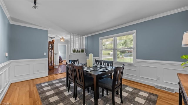 1926 Downing Dr, Burlington, NC 27215 - dining space with light wood-style floors, a wainscoted wall, ornamental molding, and a decorative wall
