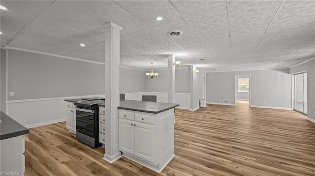 1926 Downing Dr, Burlington, NC 27215 - kitchen with stainless steel range with electric cooktop, dark countertops, white cabinets, light wood-style floors, and open floor plan