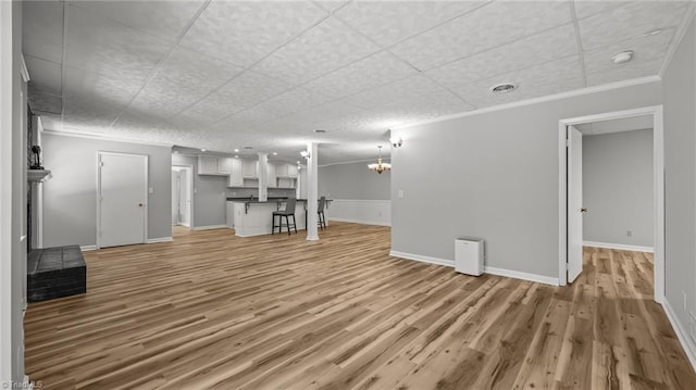 1926 Downing Dr, Burlington, NC 27215 - unfurnished living room featuring light wood-style flooring, a chandelier, and ornamental molding