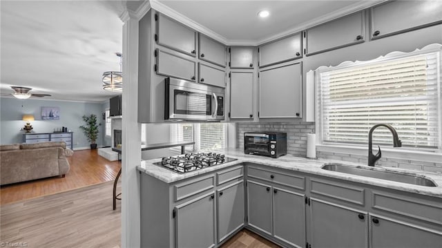 1926 Downing Dr, Burlington, NC 27215 - kitchen with gray cabinetry, stainless steel microwave, gas cooktop, healthy amount of natural light, and ornamental molding