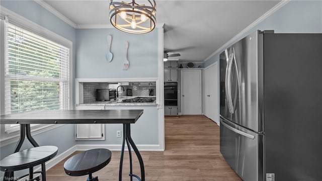 1926 Downing Dr, Burlington, NC 27215 - kitchen with stainless steel appliances, ornamental molding, a chandelier, wood finished floors, and light countertops