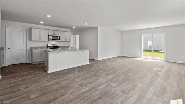 6598 Capstone Ct, Rural Hall, NC 27045 - kitchen featuring appliances with stainless steel finishes, a kitchen island with sink, wood finished floors, recessed lighting, and baseboards