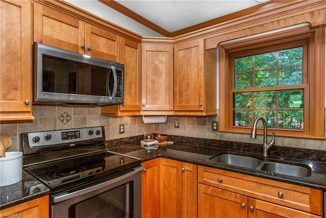 3228 Valley Rd, Winston-Salem, NC 27106 - kitchen with appliances with stainless steel finishes, brown cabinetry, dark stone counters, backsplash, and ornamental molding
