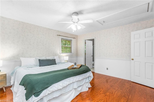 3228 Valley Rd, Winston-Salem, NC 27106 - bedroom featuring attic access, wood finished floors, wallpapered walls, and ceiling fan