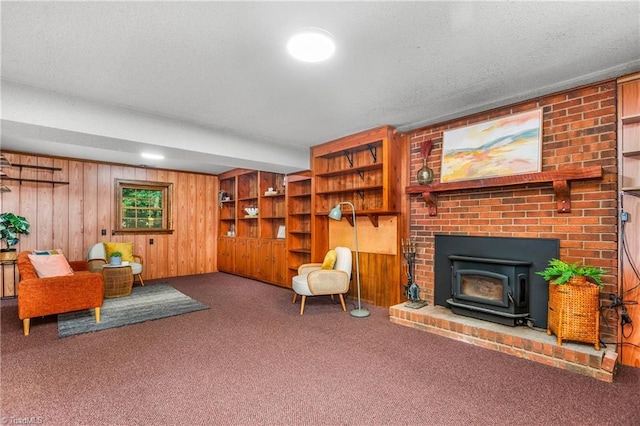 3228 Valley Rd, Winston-Salem, NC 27106 - living area with carpet flooring, a wood stove, and wood walls