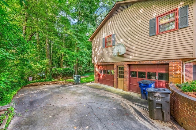 3228 Valley Rd, Winston-Salem, NC 27106 - view of side of property with a garage, brick siding, and driveway