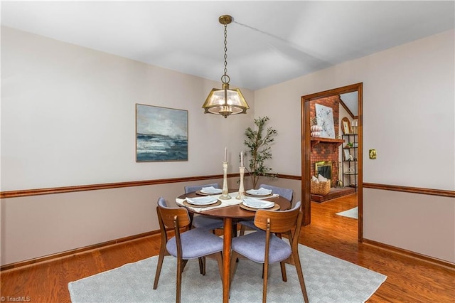 3228 Valley Rd, Winston-Salem, NC 27106 - dining space featuring wood finished floors, a chandelier, and a fireplace