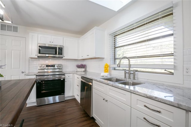 kitchen with white cabinets, stainless steel appliances, sink, and dark hardwood / wood-style flooring