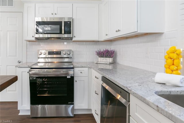 kitchen featuring stainless steel appliances, white cabinets, dark hardwood / wood-style flooring, and light stone counters