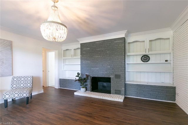 unfurnished living room featuring a brick fireplace, brick wall, dark hardwood / wood-style flooring, crown molding, and built in features