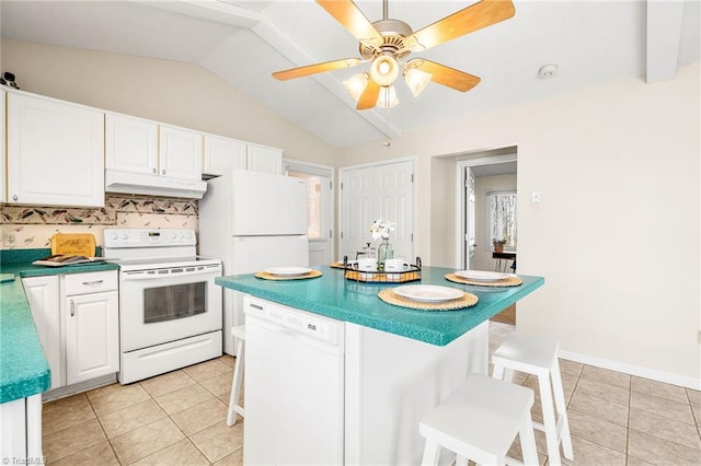 kitchen featuring light tile patterned flooring, a kitchen bar, white cabinets, and white appliances