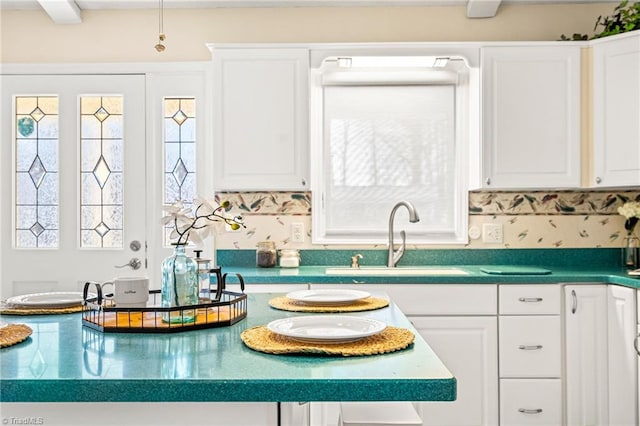 kitchen featuring white cabinetry and sink