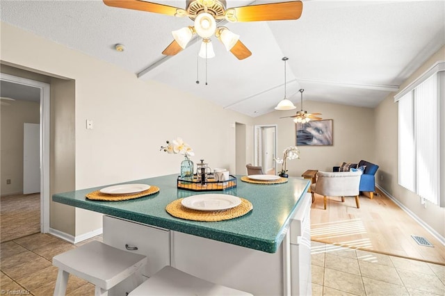 dining room featuring vaulted ceiling, ceiling fan, and tile patterned flooring