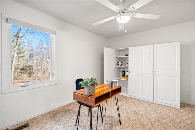 carpeted office space with ceiling fan