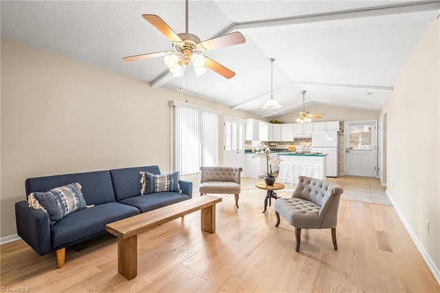 living room featuring vaulted ceiling, ceiling fan, a textured ceiling, and light hardwood / wood-style floors