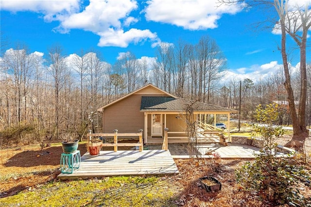 rear view of property featuring a wooden deck