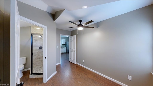 unfurnished bedroom with hardwood / wood-style floors, ceiling fan, and ensuite bath