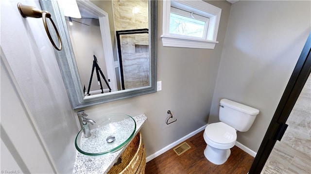 bathroom featuring vanity, hardwood / wood-style flooring, and toilet