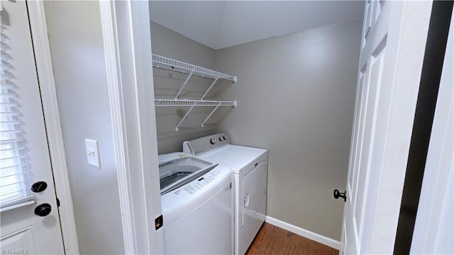 laundry area featuring washing machine and dryer and dark hardwood / wood-style flooring