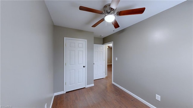 unfurnished bedroom featuring ceiling fan and dark wood-type flooring