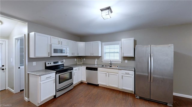 kitchen with white cabinets, sink, appliances with stainless steel finishes, and dark wood-type flooring