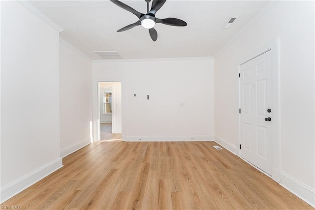 spare room featuring light wood-style flooring, baseboards, and crown molding