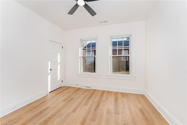 unfurnished room featuring light wood finished floors, visible vents, and baseboards