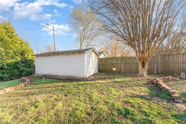 view of yard with a storage shed, fence, and an outbuilding